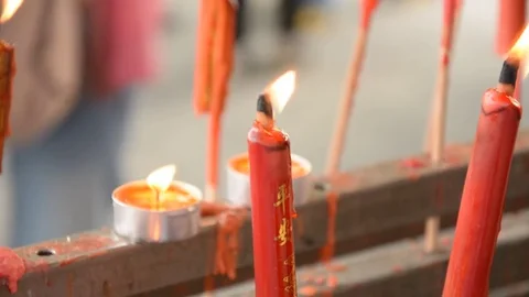 Hand cense joss stick to at an incense burne and burning candle Stock Footage 83791908