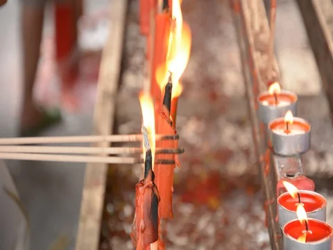 Hand cense joss stick to at an incense burne and burning candle Stock Footage 83791919