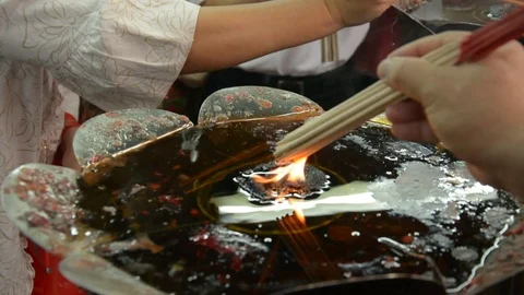 Hand cense joss stick to at an incense burne and burning candle Stock Footage 83792240