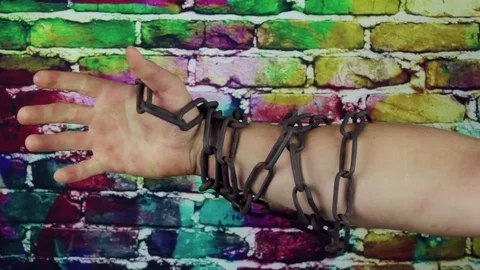 Hand in chains on color background Stock Footage 79087153