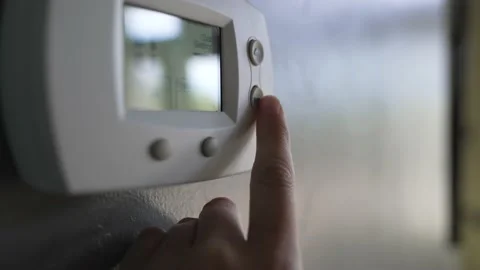 Hand changes temperature of thermostat Stock Footage 156064321