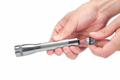 Hand changing the battery of a flash light Stock Photos