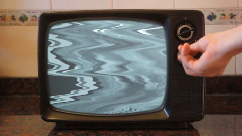 Hand Changing Channels on Retro Television in Kitchen Vidéo 332874904
