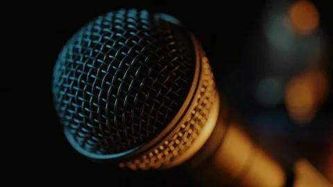 A hand is changing the head of a dynamic microphone in a half-light. Stock Footage 116846154