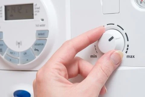 Hand Changing Setting with Dial on Boiler or Appliance Stock Photos