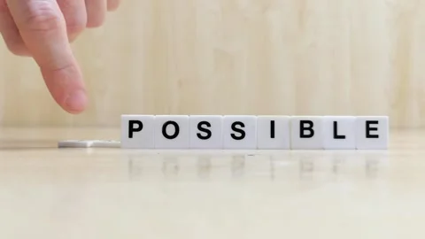 A hand changing the word impossible to possible with letters Stock Footage 246608808