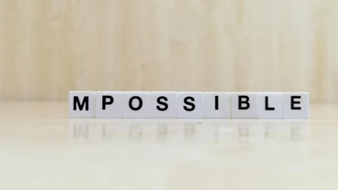 A hand changing the word possible to impossible with letters Stock Footage 246608797