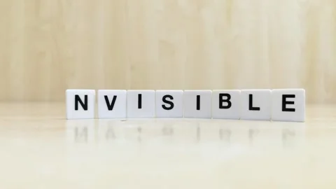 A hand changing the word visible to invisible with letters Stock Footage 246608813