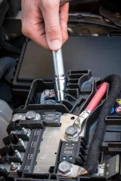 Hand checking the bolt of a car battery with a wrench Stock Photos