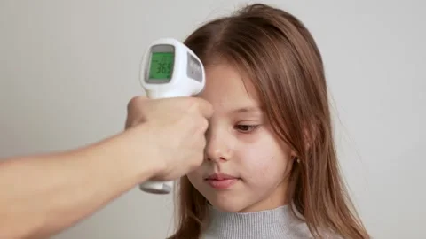 Hand checking child's temperature with infrared forehead thermometer Video stock 261003777