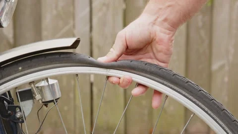 Hand checking flat bicycle tire Stock Footage 244921062