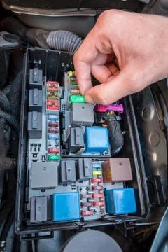 Hand checking a fuse in a car engine Stock Photos