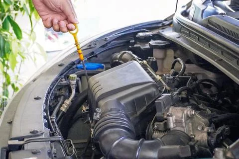 A hand checking the oil level in the engine before a trip or trip, car condit Stock Photos