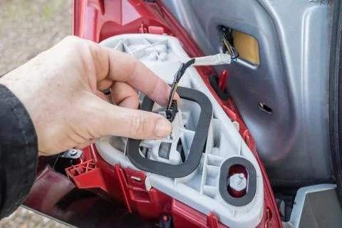 A hand checking or replacing  a taillight lamp Stock Photos