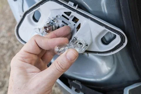 A hand checking or replacing  a taillight lamp Stock Photos