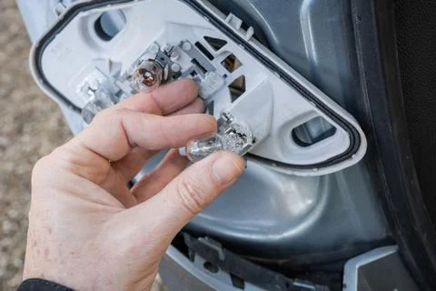 A hand checking or replacing  a taillight lamp Stock Photos