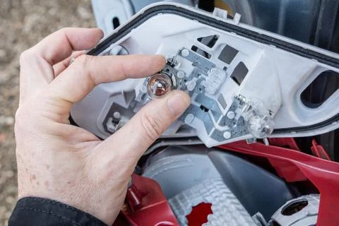 A hand checking or replacing  a taillight lamp Stock Photos