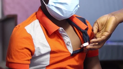 Hand checking temperature of an African child wearing surgical mask Stock Footage 171708539