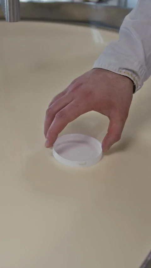 Hand of Cheesemaker Testing Thickness of Coagulated Milk in Vat Stock Footage 294160916