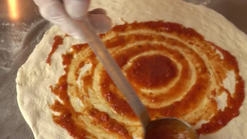 Hand Chef Cook Spread Tomato Sauce To Dough Before Preparation Pizza In Pizzeria Stock-Footage 145132960