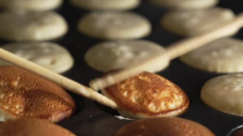 Hand of chef flip small round pancakes on hot surface delicious snack Stock Footage 321054851