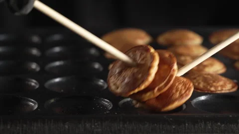 Hand of chef flip small round pancakes on hot surface delicious snack Stock Footage 321054948