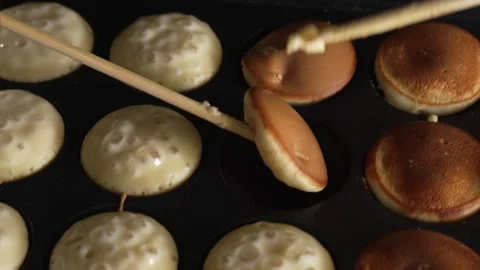 Hand of chef flip small round pancakes on hot surface delicious snack Stock Footage 321055174