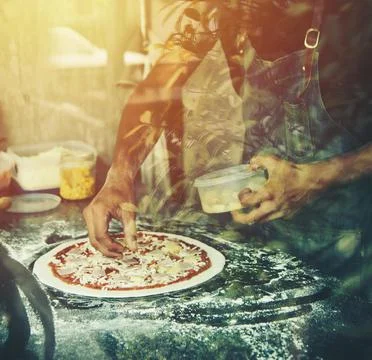 Hand Chef preparing spread cheese on pizza on marble table Stock Photos