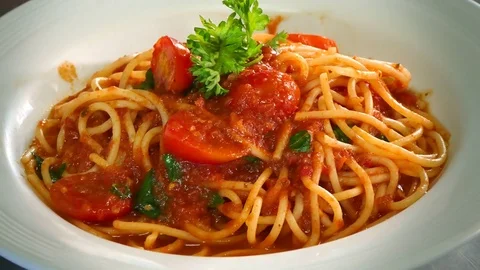 Hand of a chef puts a basil leaf on top of the pasta dish Stock Footage 78020627