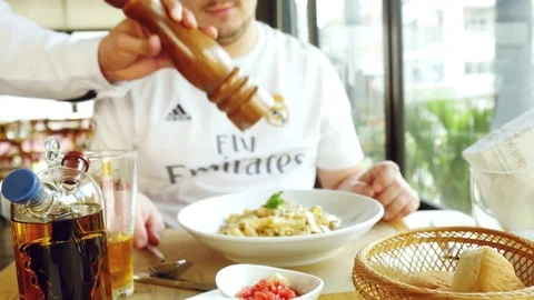 Hand of a chef puts the Parmesan over the pasta dish finished before serving in Stock Footage 75463471