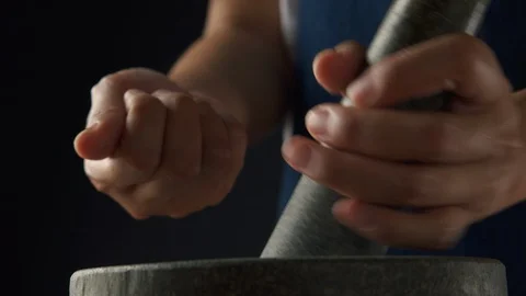Hand of chef is sprinkling black peppercorns in a stone mortar Stock Footage 120214101