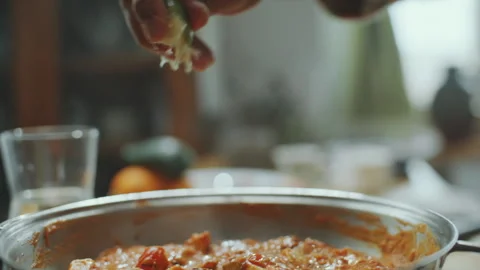 Hand of Chef Squeezing Lime Juice over Paneer Butter Masala in Pan Stock Footage 303018009