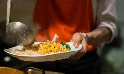 Hand of chelf put soup on crispy noodle Stock Photos