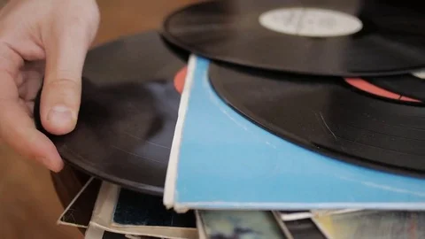 Hand chooses and pulls favorite retro vinyl record from the LP collection stack. Stock Footage 69218991
