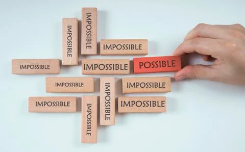Hand chooses possible cube among the cubes that says impossible Stock Photos