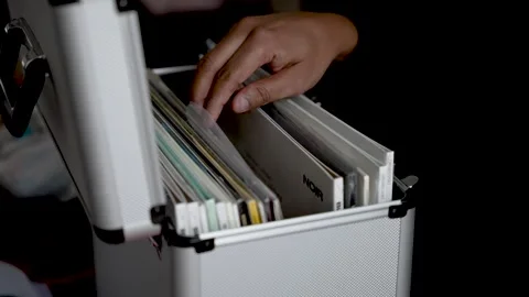 Hand choosing vinyl records from silver case Stock Footage 327479767