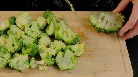 Hand Chopping Broccoli on Cutting Board in Cooking Kitchen Video stock 341446011