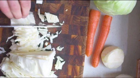 Hand chopping cabbage in the kitchen Stock Footage 76198797