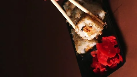 Hand with chopsticks taking portion of sushi roll. Sushi rolls with salmon Stock Footage 292116493