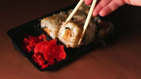 Hand with chopsticks taking portion of sushi roll. Sushi rolls with salmon Stock Footage 292116611