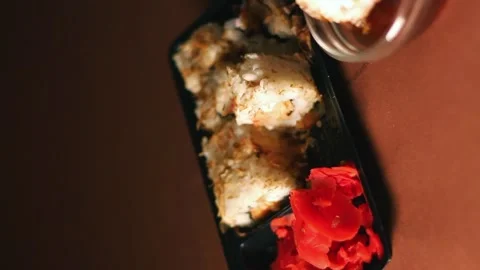 Hand with chopsticks taking portion of sushi roll. Sushi rolls with salmon Stock Footage 293195563