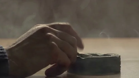 Hand with a cigarette and ashtray on the table: man smoking cigarette Stock Footage 74413312