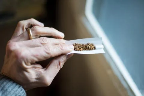 Hand with cigarette rolling Stock Photos
