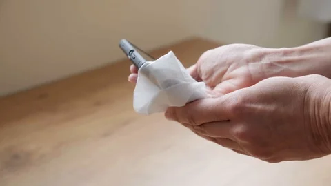 Hand clean mobile cell phone with antibacterial wet wipe at home Stock Footage 128942353