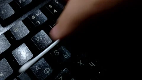 Hand cleaning antiseptic from keyboard using a cotton swab close up. Stock Footage 140886505