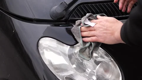 Hand cleaning a car headlight during detailing or washing. Stock Footage 326070619