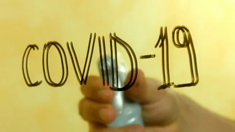 Hand cleaning Covid-19 text on mirror with disinfectant spray and rag vaccine Stock Footage 127587236