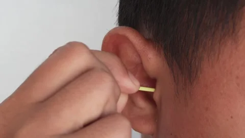 A hand is cleaning the ear with a cotton bud. Stock Footage 337811864