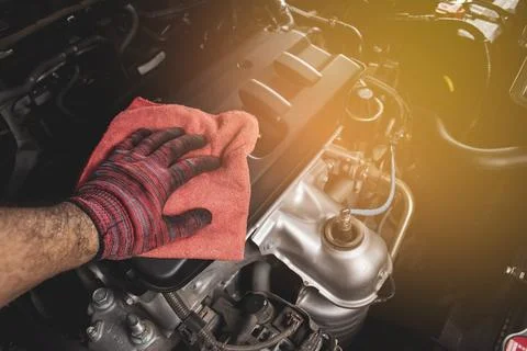 Hand is cleaning engine cover with a using red microfiber cloth,Automotive .. 스톡 사진