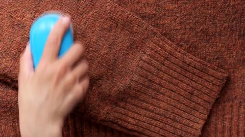 Hand cleaning lint from wool fabric using special remover Stock Footage 202340192